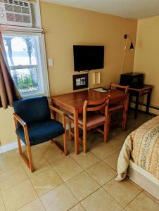 a dining room with a table and chairs and a television at Above Tide Motel in Campbell River