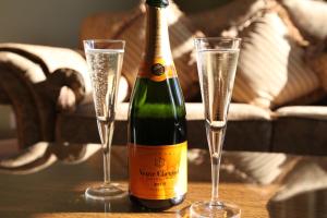 a bottle of champagne and two glasses on a table at The 25 Boutique B&B - Adults Only in Torquay