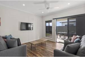 a living room with two couches and a tv at Discovery Parks - Goolwa in Goolwa