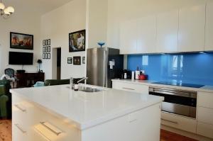 a kitchen with a white counter top and a refrigerator at Ozone Tower in Queenscliff
