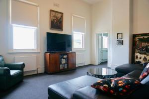 a living room with a couch and a flat screen tv at Ozone Tower in Queenscliff