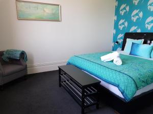 a bedroom with a bed with a table and a chair at Ozone Tower in Queenscliff