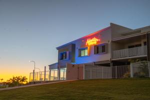 a building with a neon sign on the side of it at Mackay Adventure Lodge in Mackay