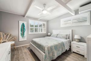 a bedroom with a bed and a ceiling fan at Castaway in Laurieton