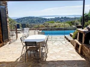 un patio con tavolo, sedie e piscina di Villa Bormes-les-Mimosas, 3 pièces, 5 personnes - FR-1-610-89 a Bormes-les-Mimosas