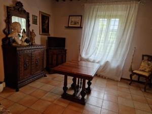 ein Wohnzimmer mit einem Holztisch und einem Fenster in der Unterkunft Casa Crevole in Palazzina
