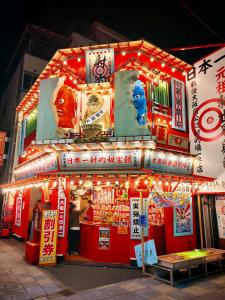 uma banca de alimentos com sinais na lateral em WuTong梧桐 通天閣徒歩1分 NEW OPEN 景区内民宿 em Osaka