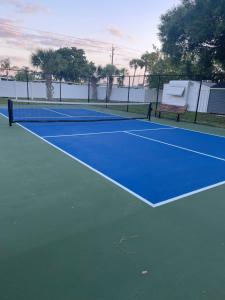 a blue tennis court with a bench on it at Home in Arbor Terrace Resort in Bradenton