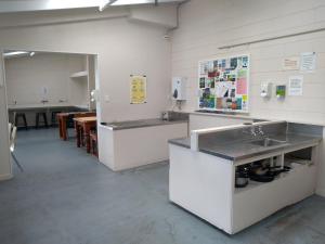 a kitchen with two sinks and a counter with a table at South Brighton Holiday Park in Christchurch