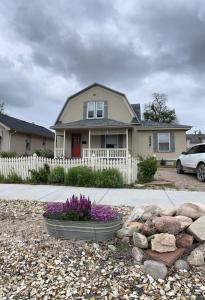 uma casa com uma cerca branca e flores num quintal em Spacious City House em Colorado Springs