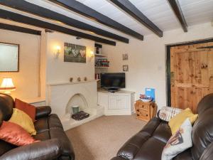 a living room with a couch and a fireplace at Lena Cottage in Great Driffield