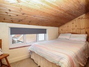 a bedroom with a bed in a room with a window at Lena Cottage in Great Driffield