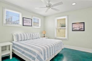 Un dormitorio blanco con una cama y dos ventanas. en Above & Beyond, en Port Aransas 20 fotos más