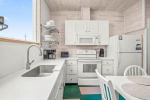 a kitchen with white appliances and a table at 7 Heaven in Port Aransas