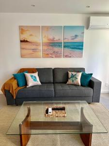 sala de estar con sofá y 4 pinturas en Novíssimo Apartamento à Beira-Mar, en Río de Janeiro