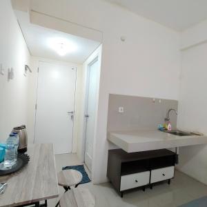 a white kitchen with a sink and a counter at RB Room Bogorienze The Jungle Bogor in Bogor