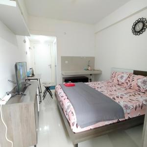 1 dormitorio con 1 cama y escritorio con TV en RB Room Bogorienze The Jungle Bogor en Bogor