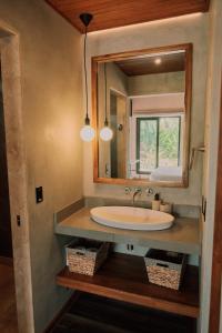 a bathroom with a sink and a mirror at Suwa Villa Arenal in Fortuna