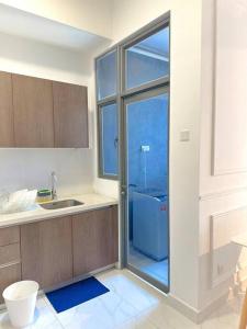 a kitchen with a sink and a blue refrigerator at #Netflix #Cuckoo Troika Kota Bharu Homestay 0118 in Kota Bharu