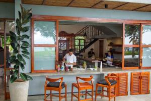 a restaurant with a bar with orange chairs at El Guayacan Retreat in El Edén