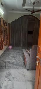 a living room with a couch and a curtain at Vacation Rental Home in Kondapalle