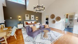 a living room with a purple couch and a table at Wine Country Modern Farmhouse on 10 Acres and Pool in Afton