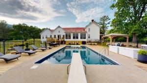 a swimming pool in front of a house at Wine Country Modern Farmhouse on 10 Acres and Pool in Afton