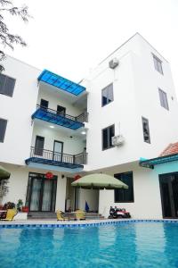 a hotel with a swimming pool in front of a building at Tam Cốc Yến Nhi Homestay in Ninh Binh