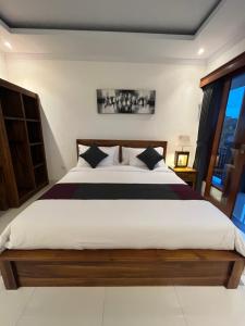 Pandu guest house في أوبود: غرفة نوم بسرير كبير ونافذة