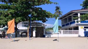two flags on the beach in front of a building at Baie Benie Beach Resort in Balibago