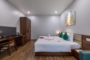 a bedroom with a bed and a desk and a television at TRUONG TIEN HOTEL in Hue