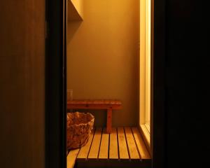 drewniana ławka siedząca w rogu pokoju w obiekcie hostel mog w mieście Ueda