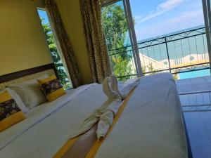 a bedroom with a large bed with a large window at Chom By The Sea in Ao Nam Mao