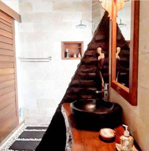 een badkamer met een zwarte wastafel en een trap bij Gili T Sugar Shack in Gili Trawangan