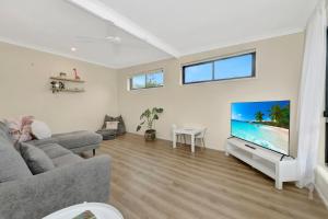 a living room with a couch and a flat screen tv at The Loft at Scotts in Scotts Head