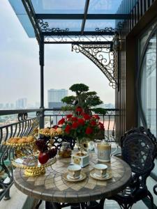 - une table avec de la nourriture et des fleurs sur le balcon dans l'établissement VP Hotel Luxury, à Hanoï