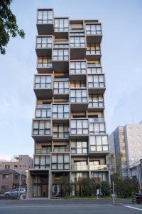 um edifício alto com muitas janelas numa rua da cidade em 9 HOTEL Hakata em Fukuoka