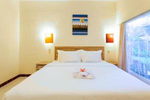 a bedroom with a large white bed with shoes on it at Utama Villas Beach Front Candidasa in Candidasa