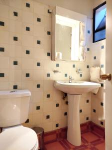 a bathroom with a toilet and a sink and a mirror at Hostal valle de la luna in Antofagasta