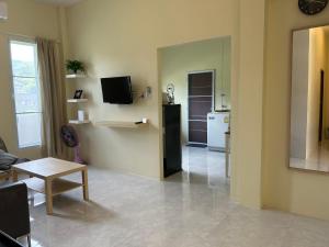ein Wohnzimmer mit einem Sofa, einem Tisch und einem TV in der Unterkunft W House Ranong 1Bedroom villa in Ranong