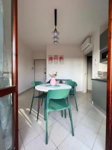 a dining room with a table and green chairs at La casa verde di Chicchi in Elmas