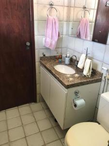 a bathroom with a sink and a toilet and a mirror at Casa Santa Paz - Gravata, próximo ao Centro in Gravatá