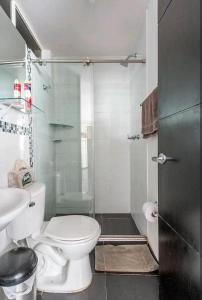 W łazience znajduje się toaleta i przeszklony prysznic. w obiekcie Alojamiento "Cómo en CASA" cerca al Aeropuerto!! w mieście Bogota