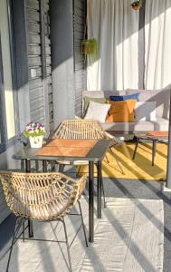 a patio with two tables and chairs and a couch at Toppilansalmi two bedroom apartment with a view in Oulu