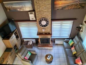 een woonkamer met een klok bij Aux 3 P'tits Wallons in Middelkerke