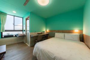 um quarto com uma cama e uma casa de banho com um lavatório em Qun Xiang Hotel em Anping
