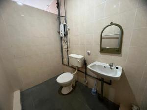 een badkamer met een toilet en een wastafel bij Leng Leng Homestay in Sibu