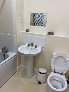 a white bathroom with a sink and a toilet at David’s apartment in London