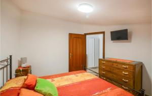 a bedroom with a bed and a dresser and a tv at 1 Bedroom Nice Home In Equi Terme in Equi Terme