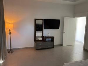 a living room with a television and a mirror at Mia's House in Puerto Peñasco